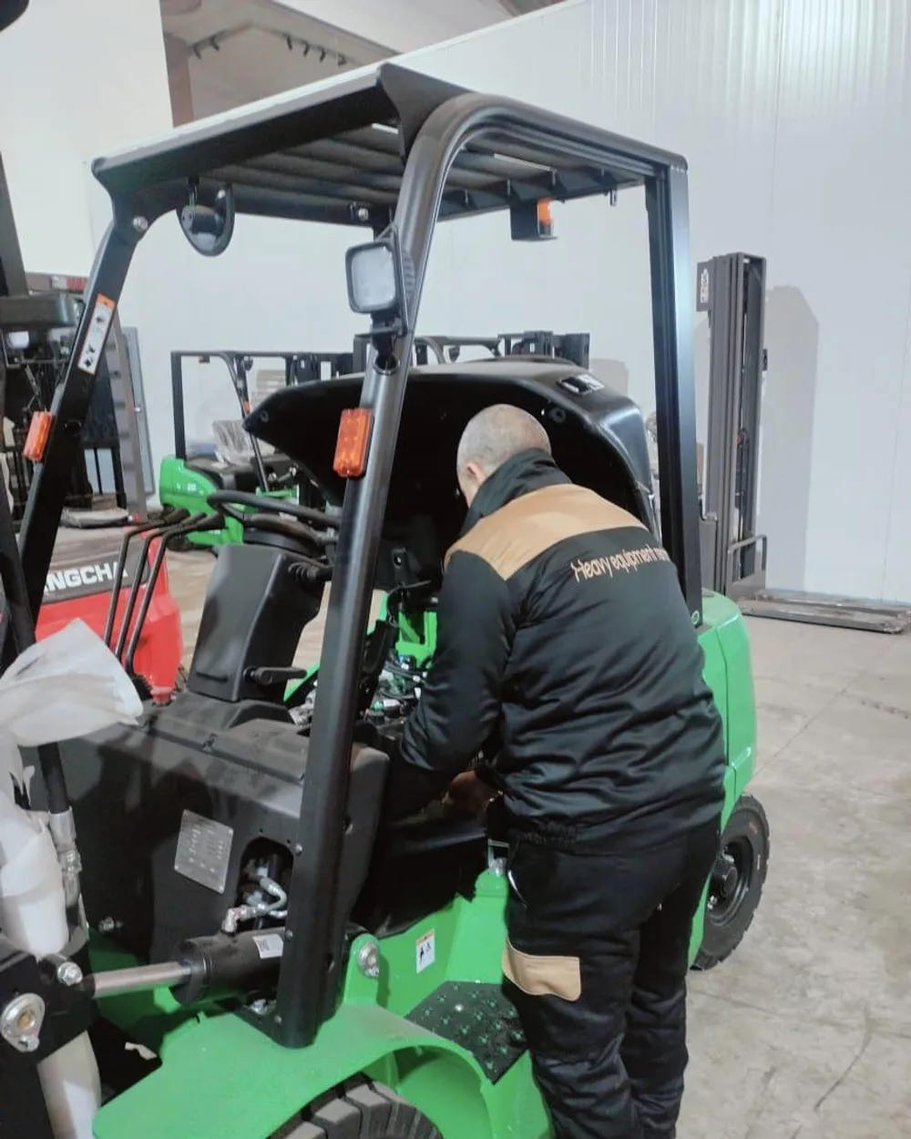 Technicien HER intervenant sur un chariot élévateur électrique en atelier