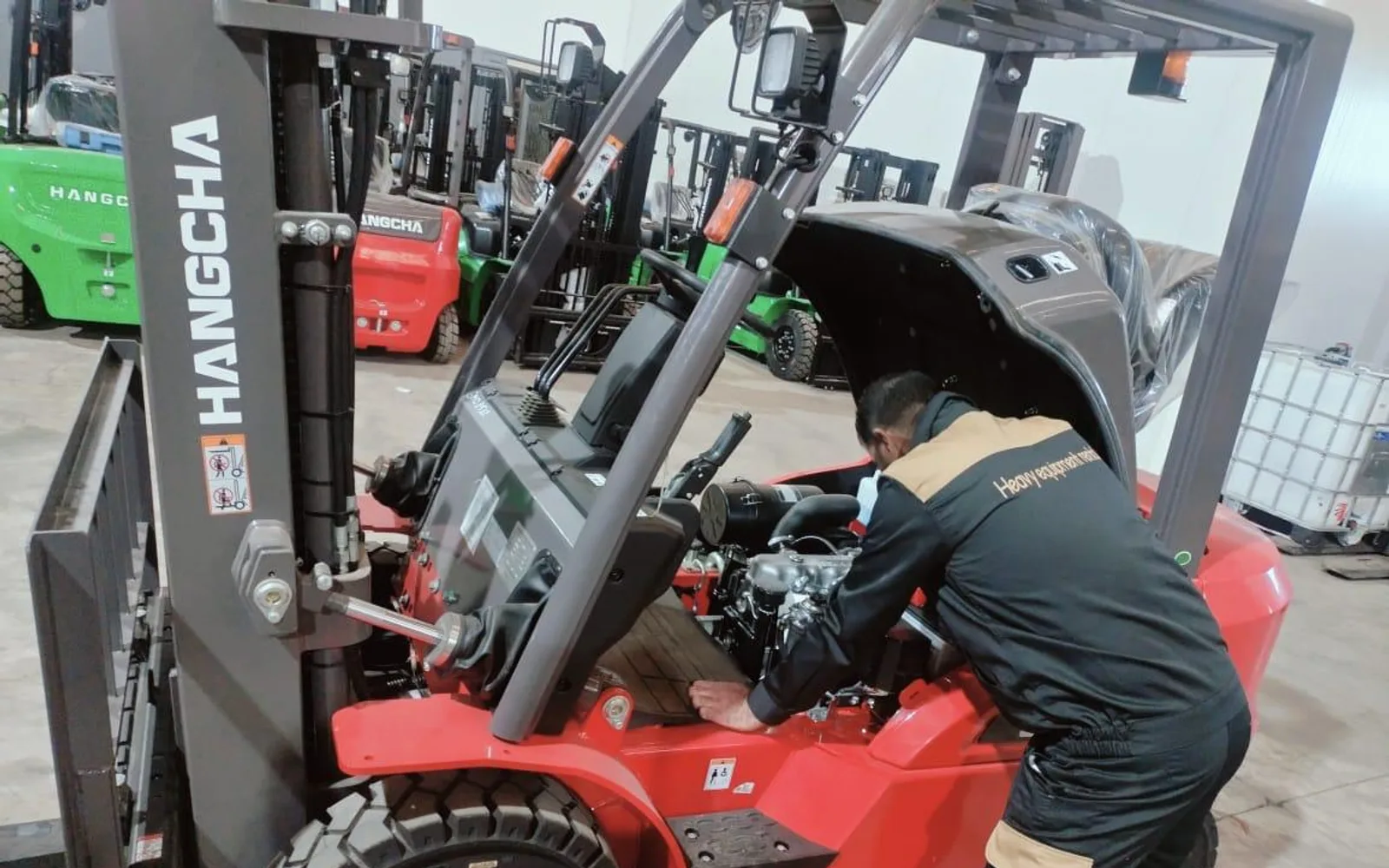 Technicien HER contrôlant le moteur d'un chariot élévateur Hangcha en atelier
