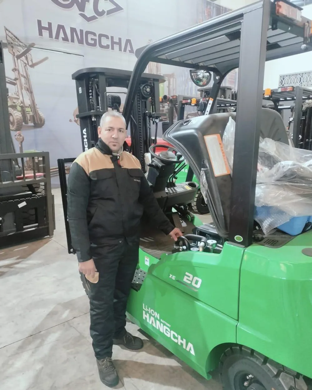 Technicien HER devant un chariot élévateur électrique Hangcha XE en atelier